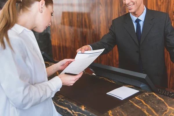 Smiling hotel werknemer helpen zijn gast — Stockfoto