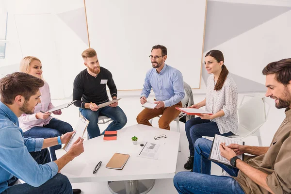 Gente sorridente seduta in cerchio — Foto Stock