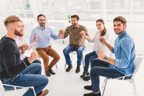 Felices personas sonrientes cogidas de la mano — Foto de Stock