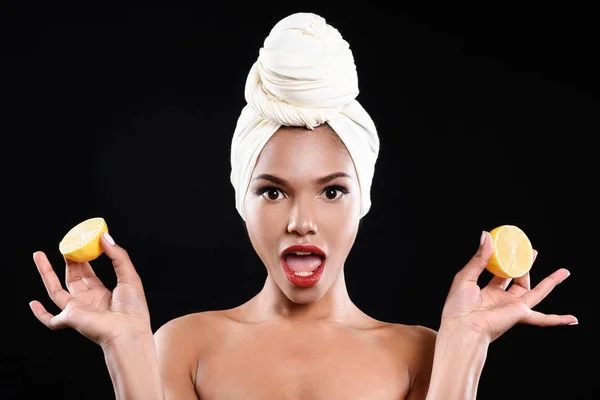Шокована дівчина мулатка тримає лимони — стокове фото