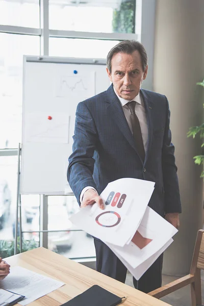 El hombre concentrado tiene papeles. — Foto de Stock