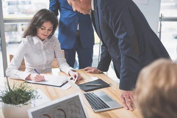 Happy woman is writing at the office — Stock Photo, Image