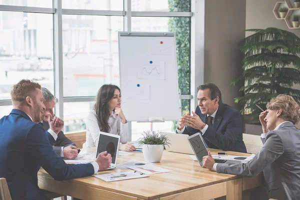 Geconcentreerde medewerkers luisteren naar hun werkgever — Stockfoto