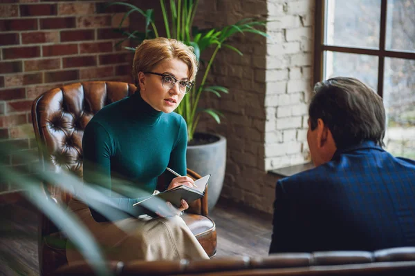 Female psychologist looking at businessman with attention — Stock Photo, Image