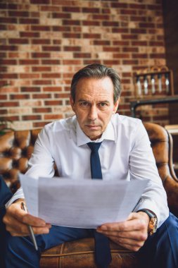 Olgun adam yorgun kameraya bakan