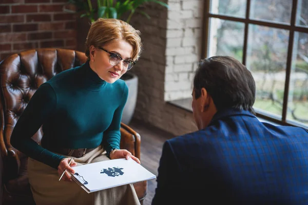 Attentive woman holding rorschach inkblot — Stock Photo, Image