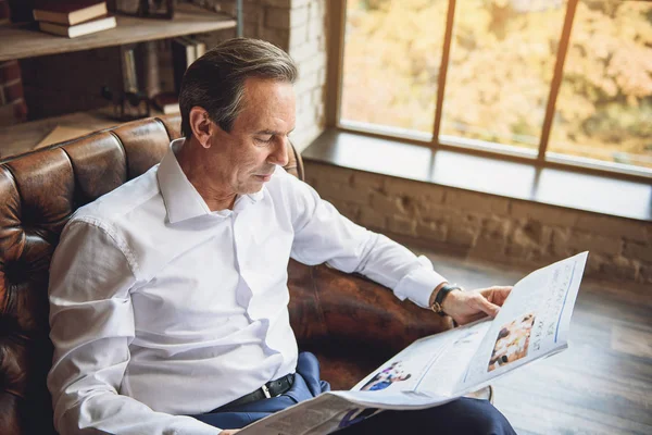 Interesado hombre sosteniendo abierto periódico — Foto de Stock