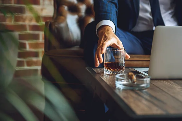 Hombre tomando vidrio con bebida ámbar — Foto de Stock