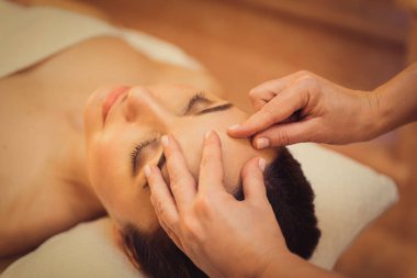 İstemci için yüz masajı yapıyor güzellik uzmanı