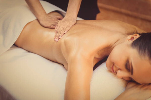 искусный косметолог массирует женское тело