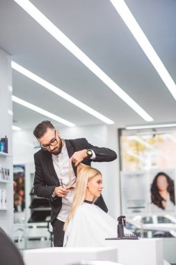 Konsantre stilist saç yapıyor