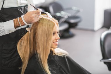 Gülümseyen kadın Kuaför salonunda oturuyor