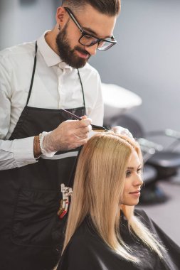Konsantre stilist bir müşteri ile çalışıyor
