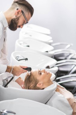 Konsantre stilist bir müşteri ile çalışıyor