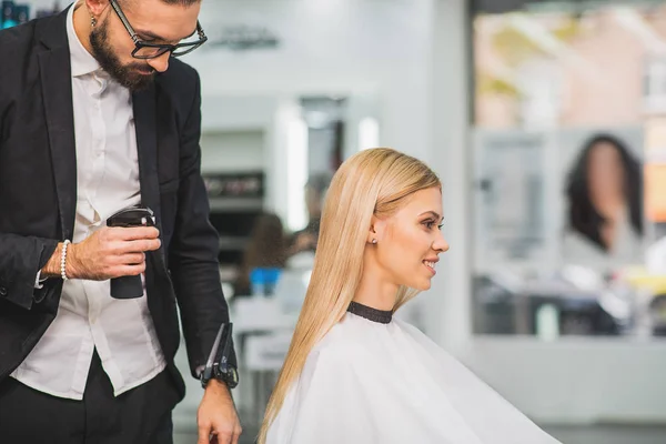 Young happy woman is getting a haircut — Stock Photo, Image
