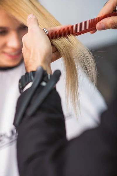 Парикмахер стрижет женские волосы — стоковое фото
