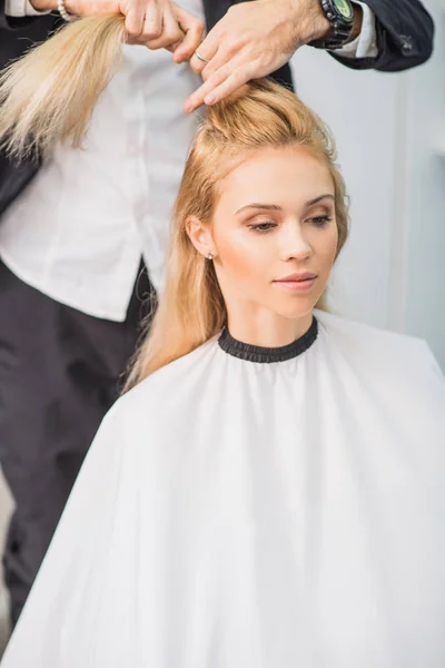 Jovem mulher está recebendo um penteado — Fotografia de Stock