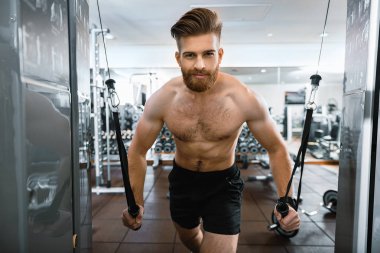 Spor salonunda sakallı gülümseyen adam