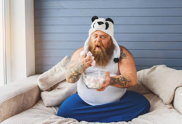 Greedy male heavy eater with sweet food — Stock Photo, Image
