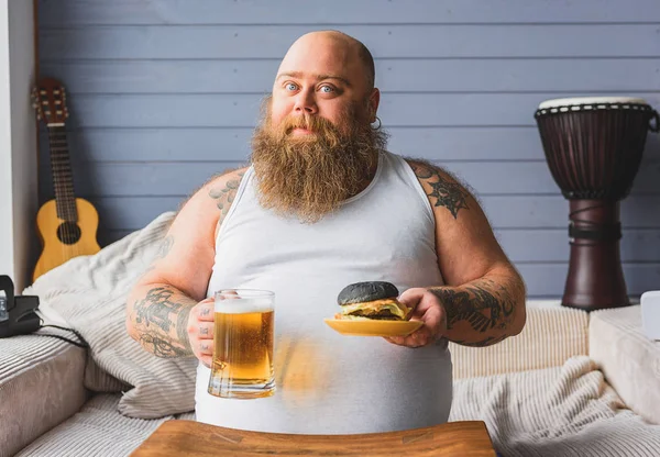 脂肪質の人が不健康な食品を食べる — ストック写真