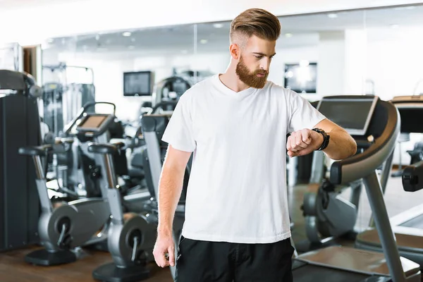 Beabsichtigter bärtiger Sportler kontrolliert Zeit — Stockfoto