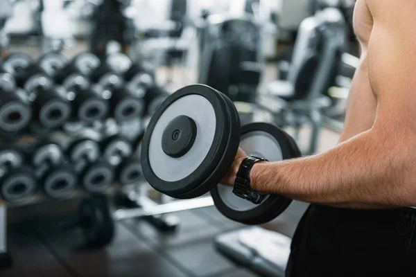 Strong man holding weights in gym — Stock Photo, Image