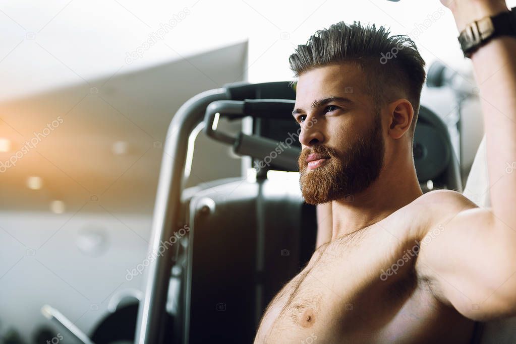 Young confident man in gym