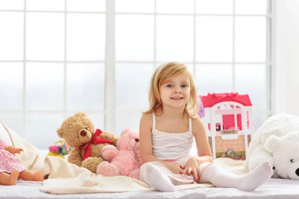 Alegre niña jugando en el dormitorio — Foto de Stock