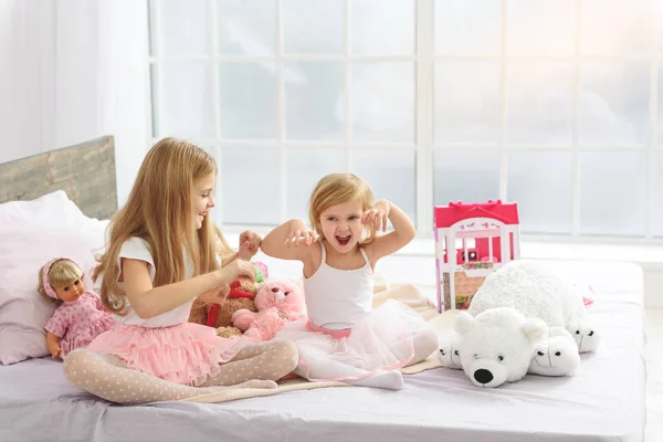 Šťastné děti si spolu hrají v ložnici — Stock fotografie