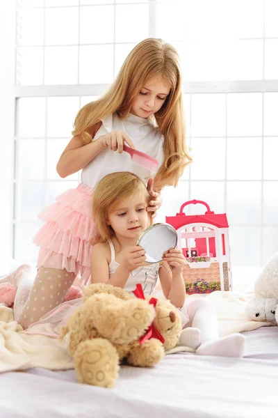Radostné sourozenci dělá účes v ložnici — Stock fotografie
