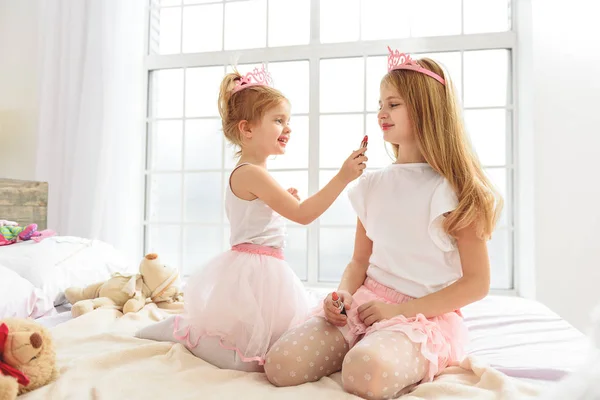 Hermosos niños divirtiéndose con cosméticos — Foto de Stock