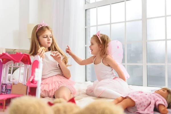 Chicas despreocupadas comiendo pastel en la cama —  Fotos de Stock