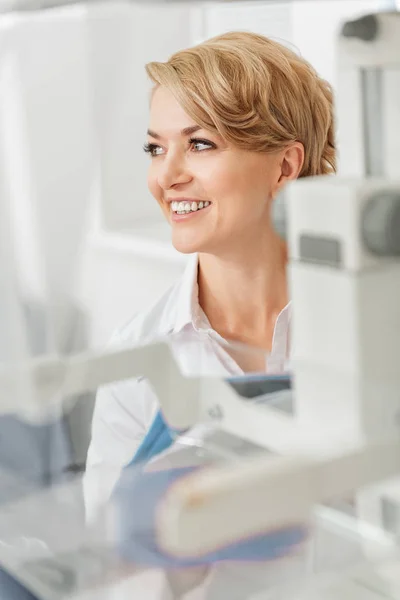 Усміхнена жінка-лікар біля пристроїв — стокове фото