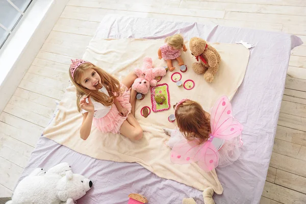 Joyful two princesses playing in bun-fight — Stock Image Joyful two princesses playing in bun-fight Stock Photo