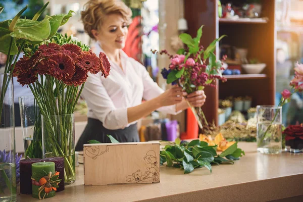 Happy woman making flower masterpiece — Stock Photo, Image