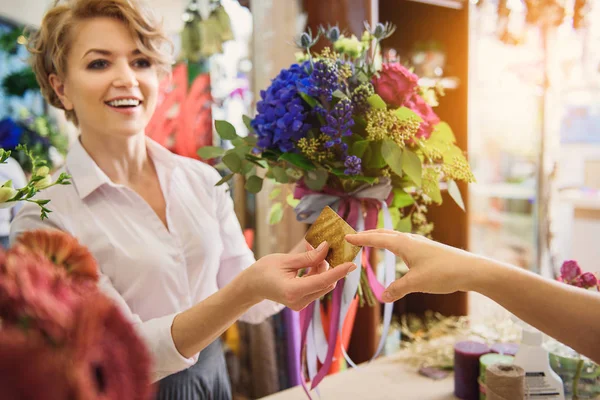 Female florist getting credit card for bouquet — Stock Photo, Image
