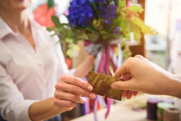 Client giving payment for flowers to saleswoman — Stock Photo, Image