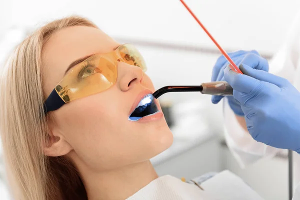 Стоматолог вивчає рот молодої жінки — стокове фото