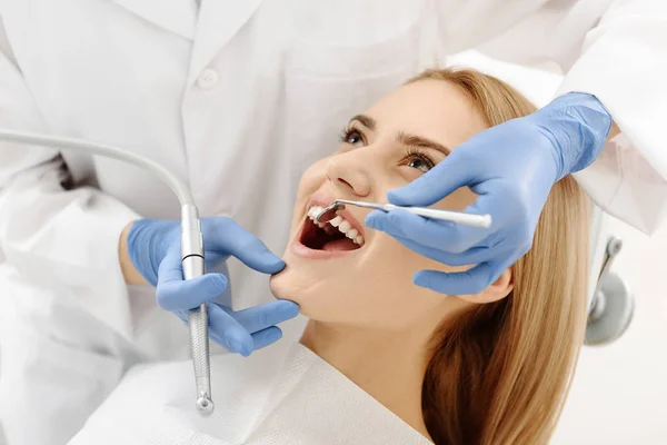 Tandläkaren undersöker tänderna av klienten — Stockfoto