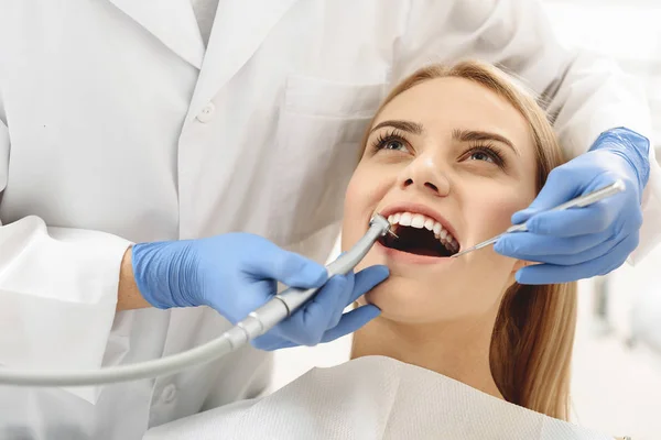 Dentista comenzando operación común de limpieza de la boca femenina — Foto de Stock