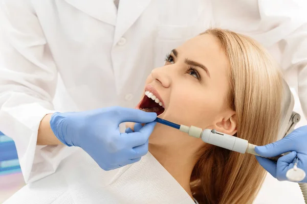 Cirujano dental poniendo bomba en la boca de la mujer — Foto de Stock
