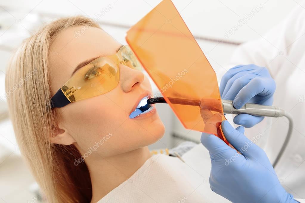 Odontologist taking a look of female teeth