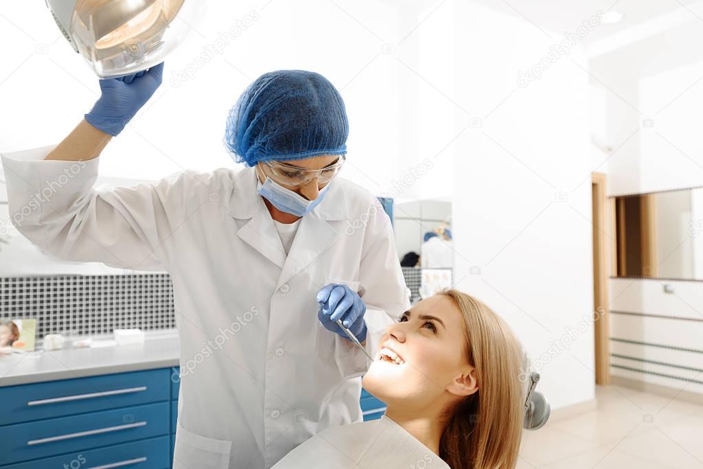 Stomatologist inspecting oral cavity of patient