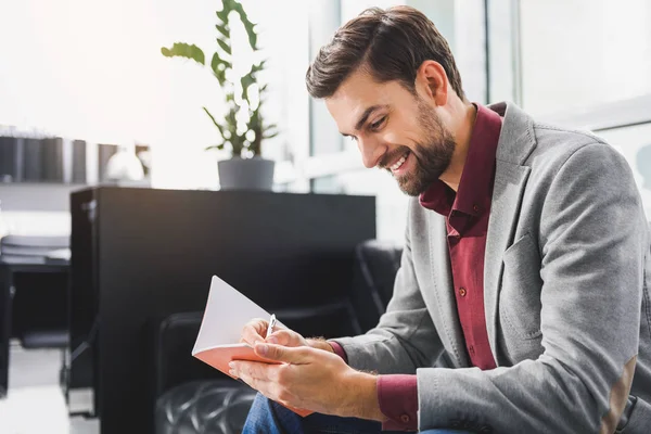 Hombre de negocios alegre tomando notas con alegría — Foto de Stock