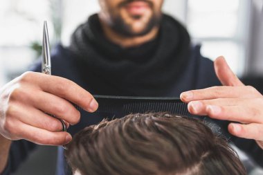 Müşteri için bir saç modeli geçiren usta stilist