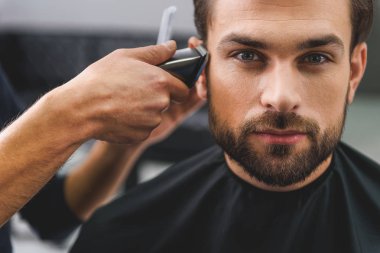 Güzellik salonunda oturan kendine güvenen adam