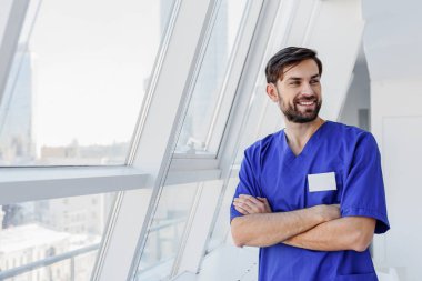 Neşeli genç doktor klinikte gülümseyen