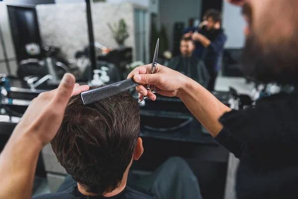 Hairdresser doing hairstyle for young man — Stock Photo, Image
