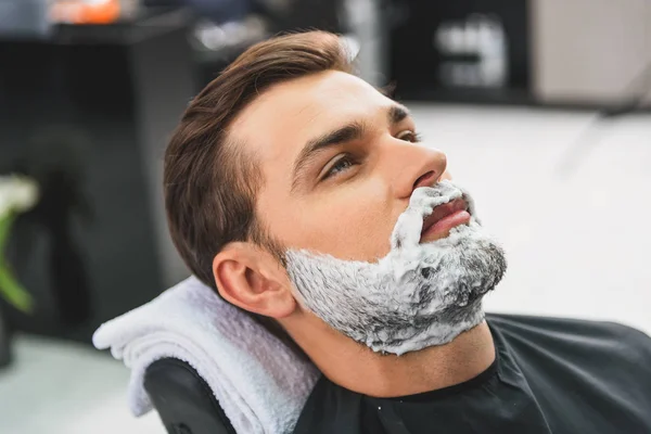 Розслаблений хлопець лікує обличчя у перукарів — стокове фото
