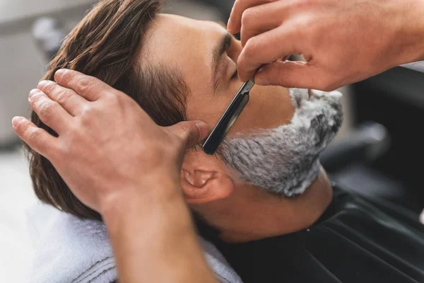 Профессиональный парикмахер избавляется от мужской щетины — стоковое фото